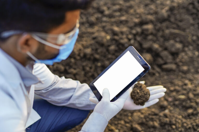 Indian agronomist checks the quality of soil in the field